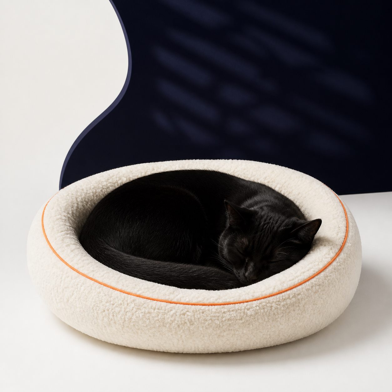Black cat sleeping in a soft cream cat bed